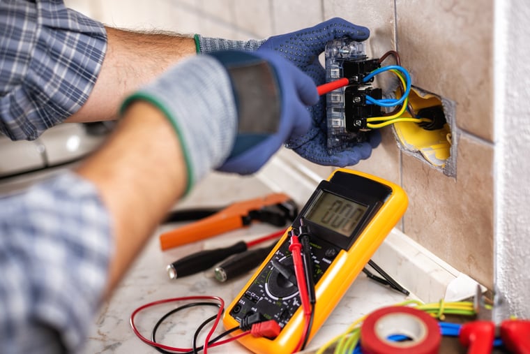Electrician at work with safety equipment on a residential electrical system